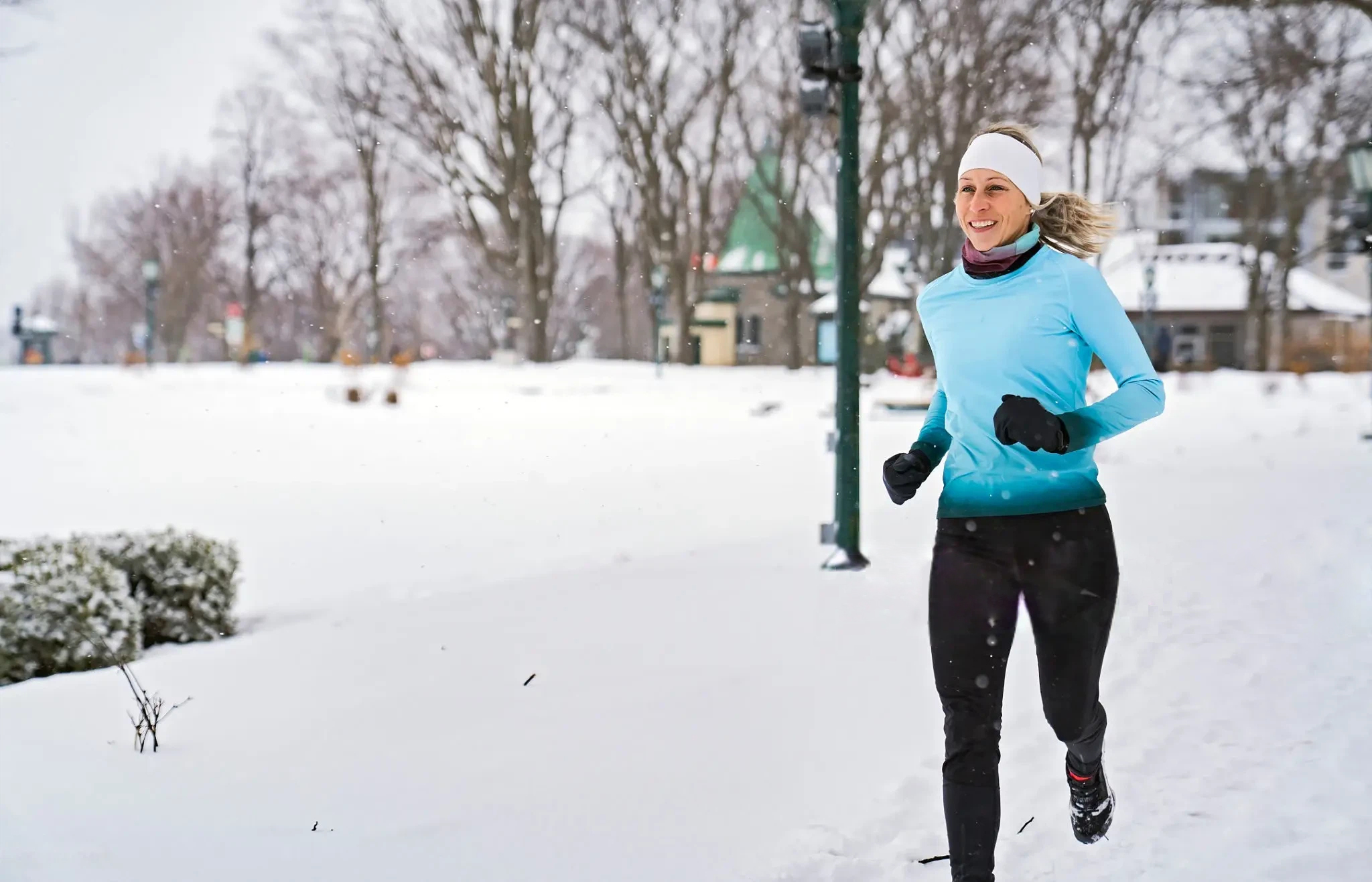 How to layer for cold weather runs — three-layer running outfit laid flat on snow-covered ground