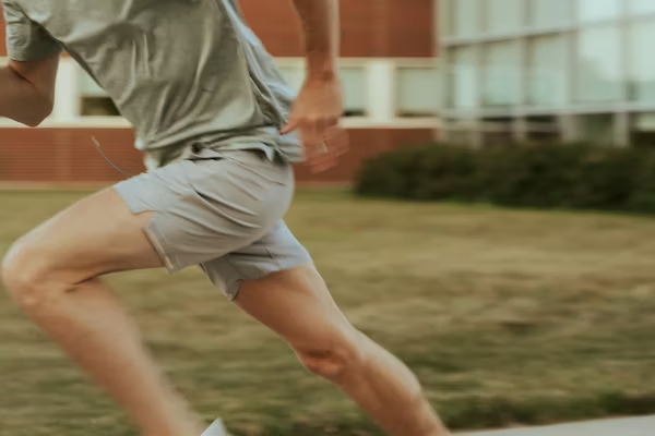 Running shorts inseam length comparison — three inseam lengths on track in afternoon light