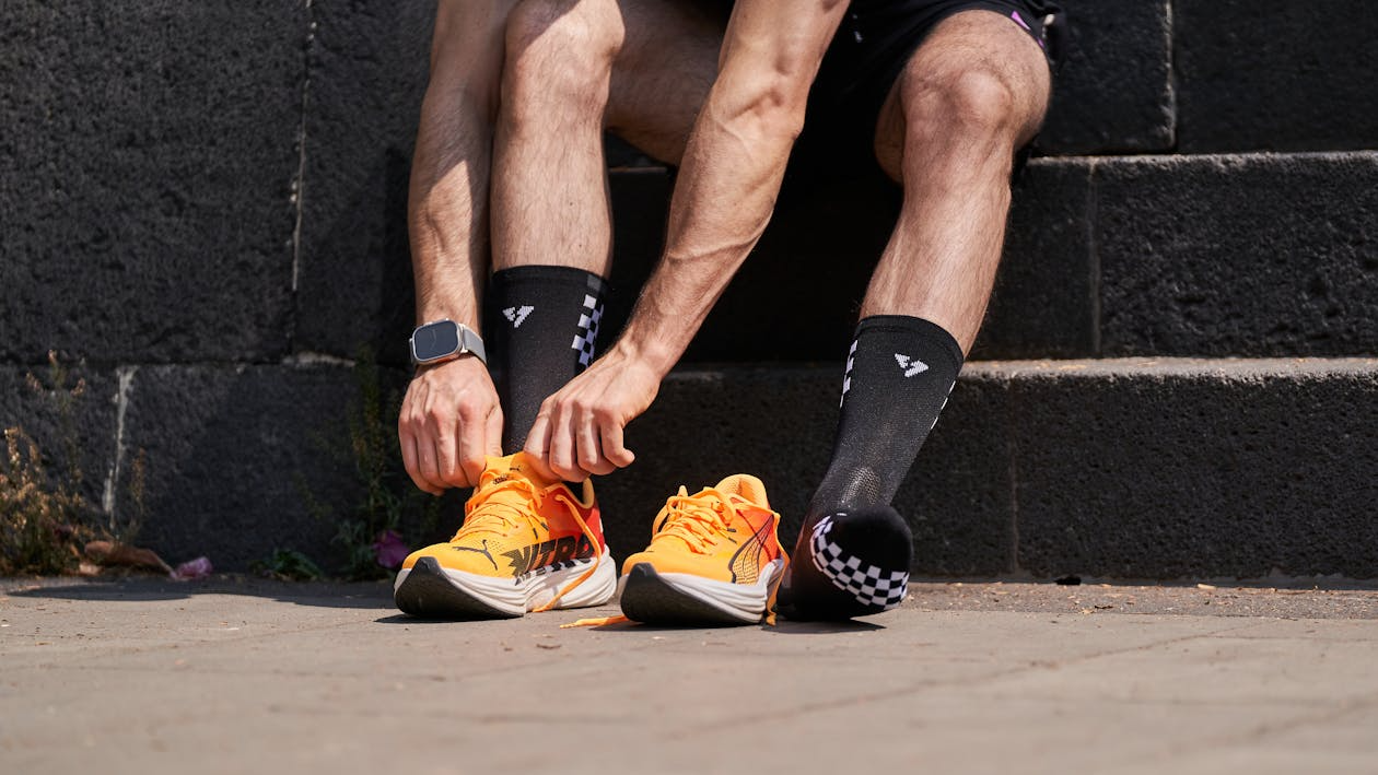 Running sock guide — merino running socks close-up on trail runner's feet on rocky path