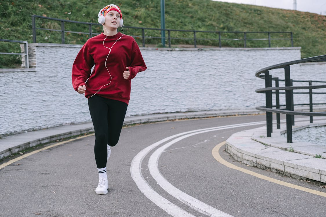 Running headphones that stay in ear — earbud close-up on runner in motion