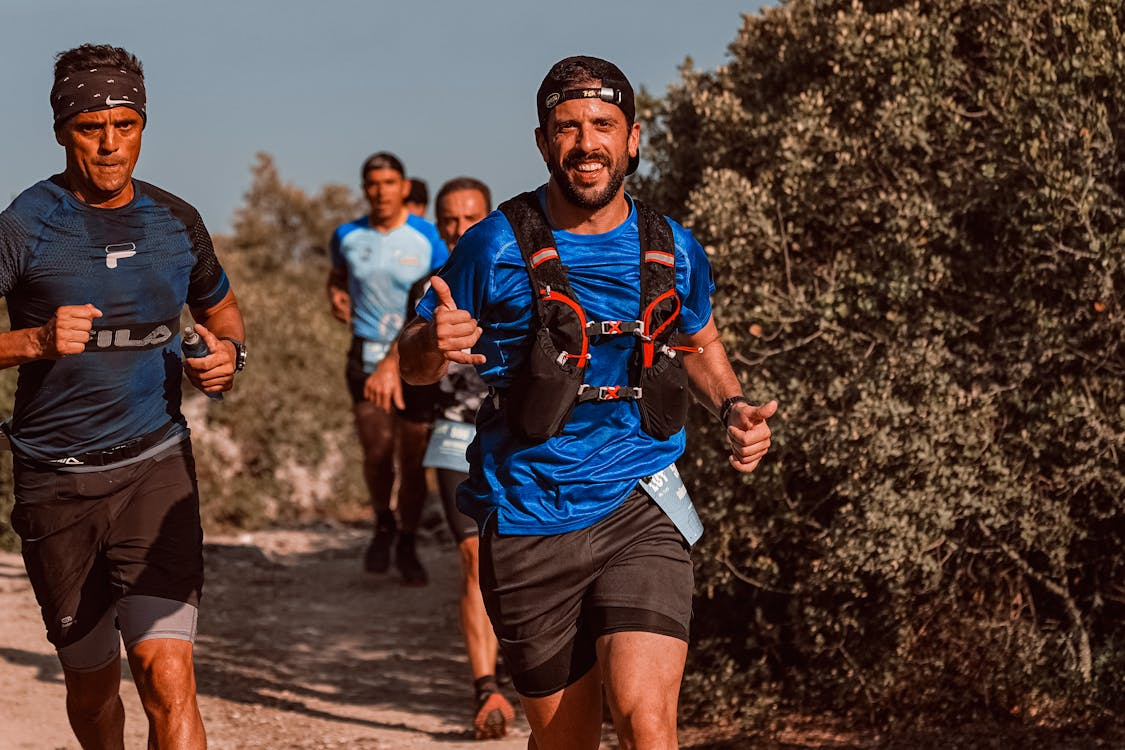 Running hydration vest size guide — trail runner with vest on mountain ridge