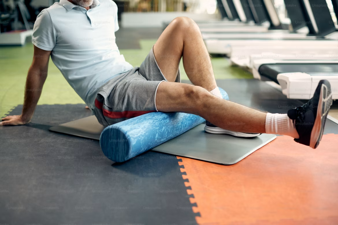 Best running recovery tools ranked — foam roller compression sleeve and percussion device on floor
