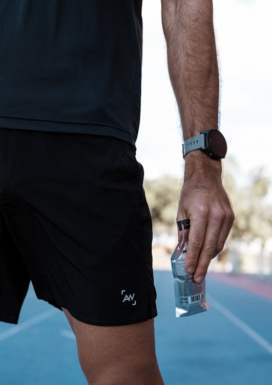 Maurten vs GU energy gel comparison — two gel packets on race course surface
