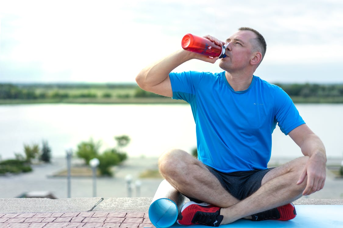 Running hydration heat guide — runner drinking from soft flask in hot conditions
